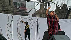 O artista mexicano-triqui Carlos CGH, vestindo um “gabán” preto e vermelho, uma peça de vestuário nativa do povo Triqui,  na Cidade do México, terça-feira, 6 de agosto de 2024