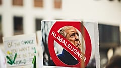 A sign with Donald Trump reading 'climate denier'. 