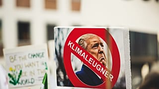 A sign with Donald Trump reading 'climate denier'. 