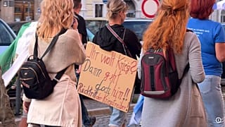Διαδηλωτής στο Goerlitz κρατά ταμπλό που γράφει: "Θέλεις τον πόλεμο; Τότε πήγαινε εκεί."