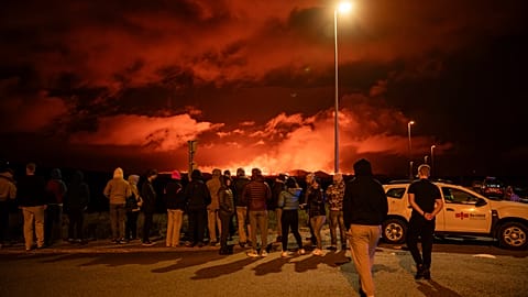 Turistas y visitantes intentan ver la erupción desde la distancia desde la intersección entre Reykjanesbraut y la carretera a Grindavik, el jueves 22 de agosto