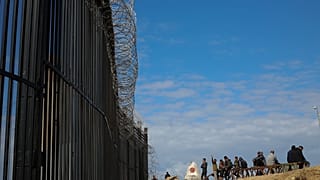 فلسطينيون نازحون جراء الهجوم الجوي والبري الإسرائيلي على قطاع غزة يجلسون بجوار السياج الحدودي مع مصر، الأربعاء، 24 يناير 2024