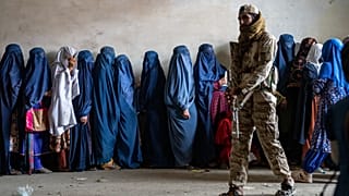 FILE - Afghan women wait to receive food rations distributed by a humanitarian aid group, in Kabul, Afghanistan, May 23, 2023. 
