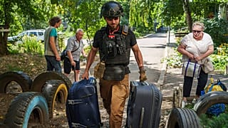 متطوع في "East SOS" يساعد في حمل أكياس النازحين في سيليدوف، منطقة دونيتسك، أوكرانيا، يوم الاثنين، 19 أغسطس 2024