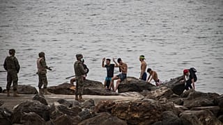 الجيش الإسباني يتخذ مواقعه مع وصول رجال معظمهم من المغرب إلى الأراضي الإسبانية بالقرب من حدود المغرب وإسبانيا، في جيب سبتة الإسباني، يوم الثلاثاء 18 مايو/أيار 2021.