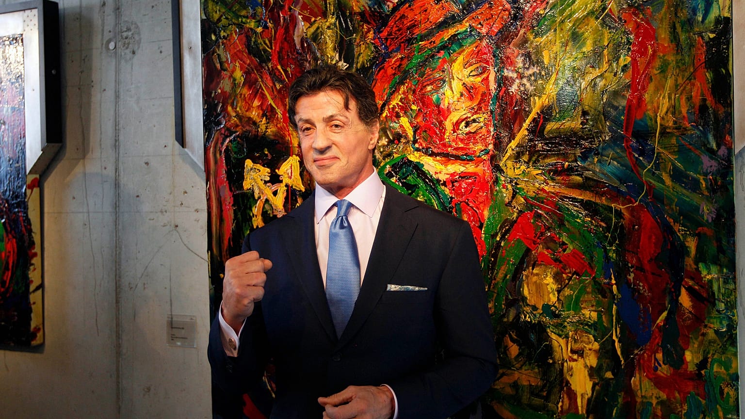 El actor estadounidense Sylvester Stallone posa frente a una de sus obras con motivo de la exposición 'Sylvester Stallone. 35 años de pintura', en 2011.