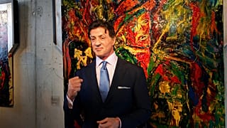 US Actor Sylvester Stallone, poses in front of one of his works during a press conference ahead of the exhibition "Sylvester Stallone. 35 Years of Painting" in 2011.