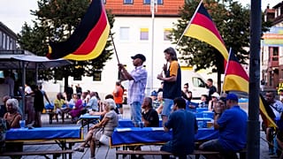 Supporters of the far-right Alternative for Germany party, or AfD, hold German national flags as they attend an election campaign rally of the party for upcoming state electio