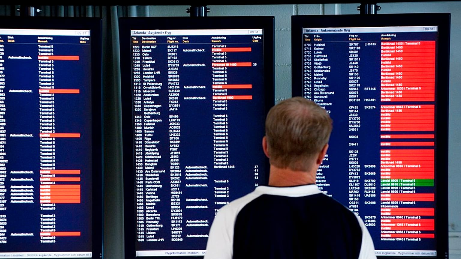 Um passageiro olha para os ecrãs de informação que mostram os voos cancelados no aeroporto de Arlanda, nos arredores de Estocolmo