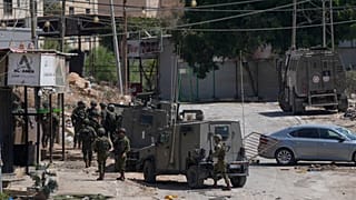 Members of Israeli forces patrol a street during a military operation in the West Bank refugee camp of Al-Faraa, Wednesday, Aug. 28, 2024.