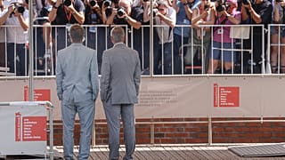 Brad Pitt, left, and George Clooney pose for photographers upon arrival for the press conference of the film 'Wolfs'
