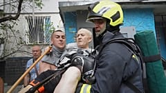 Soccorritori trasportano un anziano dopo che una bomba russa ha colpito un condominio a Kharkiv in Ucraina (30 agosto 2024)