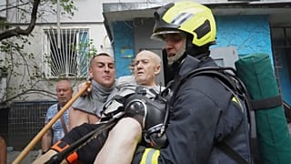 Soccorritori trasportano un anziano dopo che una bomba russa ha colpito un condominio a Kharkiv in Ucraina (30 agosto 2024)