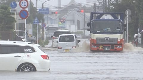 Des véhicules tentent de circuler sur les routes inondées à Hiratsuka