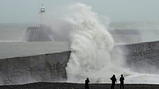 Waves crash over Newhaven Lighthouse and the harbour wall in Newhaven, southern England, November 2023, driven by Storm Ciaran.