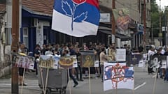 Bir kişi, Kosova'nın Mitrovica kentindeki köprüdeki barikatın bir parçası olan yanmış bir kamyonun fotoğraflarını çekiyor, 29 Aralık 2022.