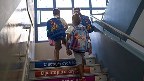 Students walk upstairs to enter class on their first day of school in Piraeus, September 12, 2022