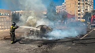رجل إطفاء يعمل على إخماد النيران التي اشتعلت بمركبة في مدينة بلغورود الروسية جراء قصف أوكراني