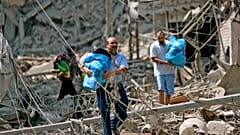 لبنانيون من سكان الضاحية الجنوبية لبيروت يجمعون أمتعتهم أثناء فرارهم من منازلهم المدمرة في لبنان في 23 يوليو/تموز 2006. 