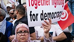 ملف - امرأة ترفع لافتة خلال مظاهرة ضد الرئيس التونسي قيس سعيد في تونس العاصمة، تونس، الأحد، 15 مايو/أيار 2022.