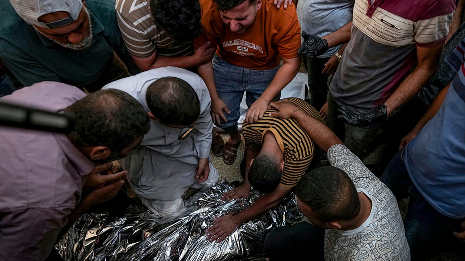 Palestinians mourn a relative killed in the Israeli bombardment of the Gaza Strip at a hospital morgue in Deir al-Balah, Sunday, Sept. 1, 2024.