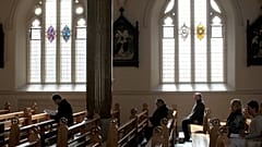 In this March 21, 2010 file phtoo, Roman Catholics listen during mass at St. Peter's Roman Catholic Cathedral, in West Belfast, Northern Ireland.
