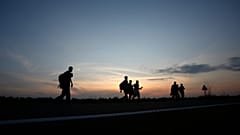A group of Migrants walking along the road close to the Serbian-Hungarian border near the northern Serbian town of Kanjiza