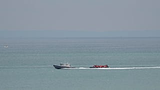 Un'imbarcazione con a bordo dei migranti viene scortata da una nave della Gendarmeria nazionale francese al largo della spiaggia di Wimereux, Francia, 4 settembre 2024