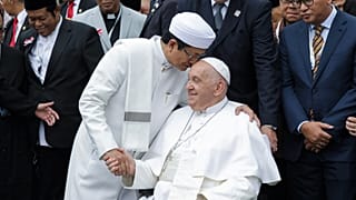 Papa Francis, sağda, ve İstiklal Camii Büyük İmamı Nasaruddin Umar bir aile fotoğrafı sırasında el sıkışıyor.