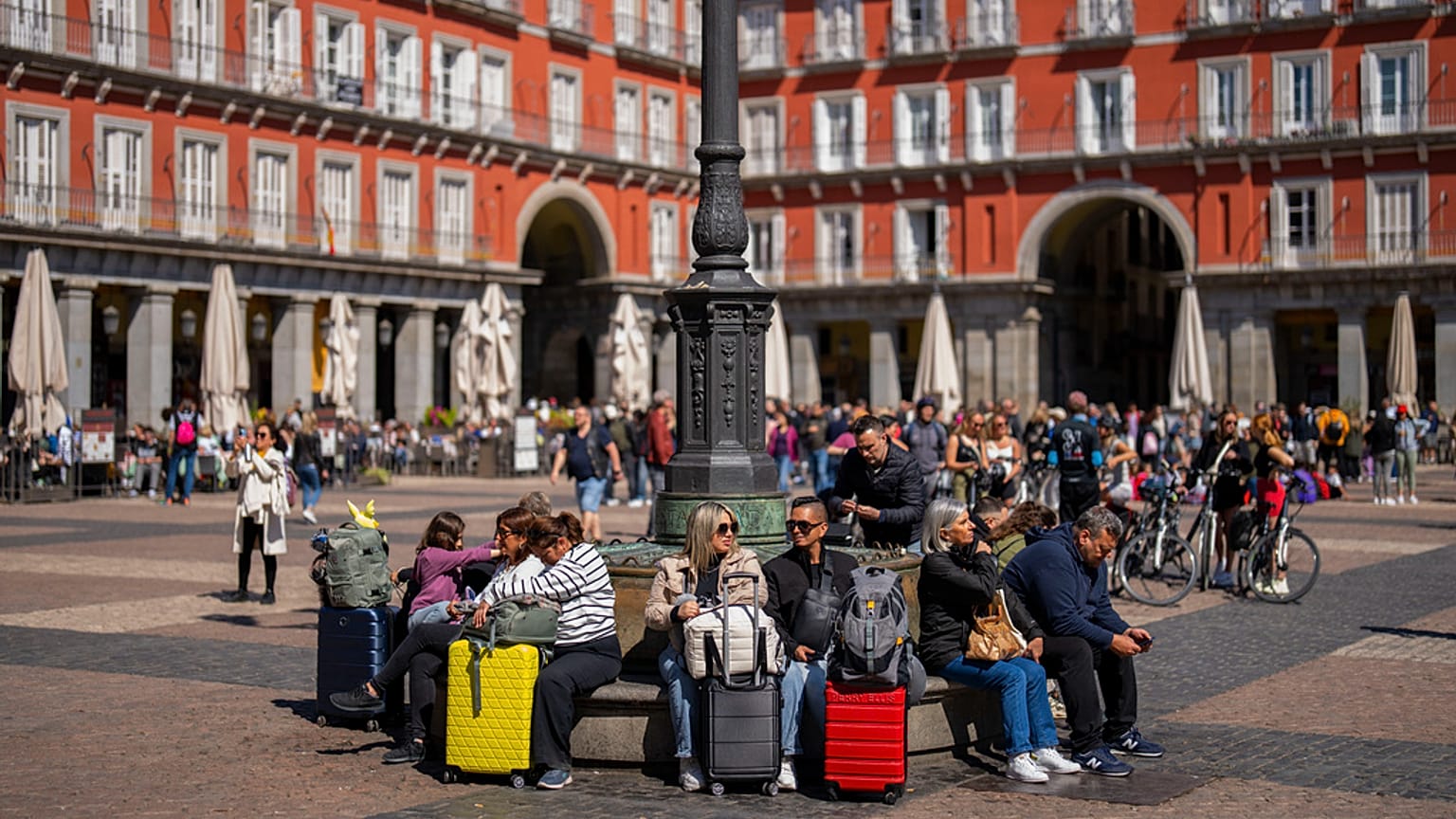 Turistas sentados num banco público na Plaza Mayor, no centro de Madrid, Espanha, segunda-feira, 29 de abril de 2024.
