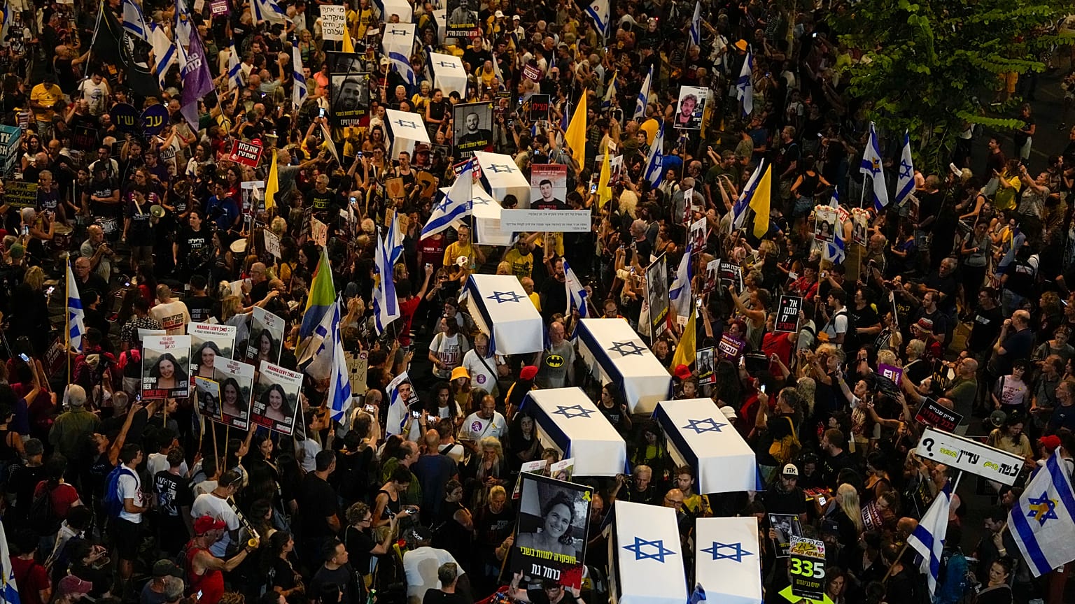 Persone trasportano finte bare coperte da bandiere israeliane che rappresentano i 27 ostaggi i cui corpi sono stati recuperati a Gaza, 5 settembre 2024