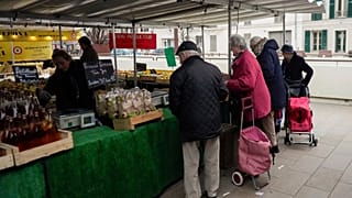 People shop at an open air market in Fontainebleau, south of Paris, France