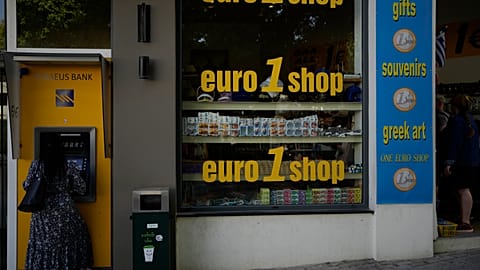 A woman uses an ATM machine in the main town of the Aegean Sea island of Rhodes, May 10, 2022
