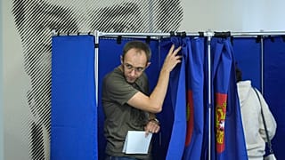 Um homem sai de uma cabina de voto durante as eleições regionais e municipais de três dias em São Petersburgo, Rússia, sexta-feira, 6 de setembro de 2024