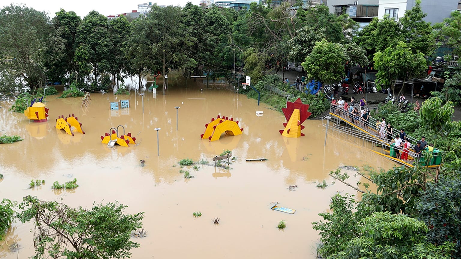 People watch a submerged dragon structure in a playground, following Typhoon Yagi in Hanoi, Vietnam on Tuesday, Sept. 10, 2024.