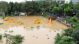 People watch a submerged dragon structure in a playground, following Typhoon Yagi in Hanoi, Vietnam on Tuesday, Sept. 10, 2024.