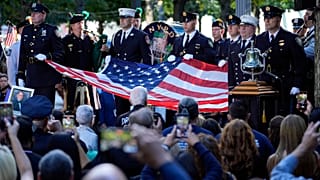 New York Polis Departmanı şeref kıtası, Ground Zero'da düzenlenen 11 Eylül anma töreni sırasında bir Amerikan bayrağı tutuyor, 11 Eylül 2024