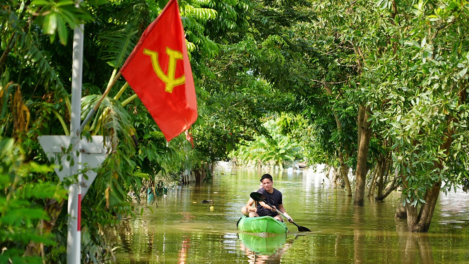 Bir adam Vietnam'da Yagi Tayfunu'nun ardından meydana gelen selde teknesiyle kürek çekiyor, 13 Eylül 2024