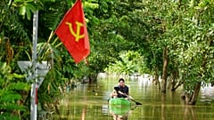 Bir adam Vietnam'da Yagi Tayfunu'nun ardından meydana gelen selde teknesiyle kürek çekiyor, 13 Eylül 2024