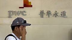Pekin'deki Fortune Finans Merkezi'nde denetim firması PwC'nin ofisinin önünden geçen bir adam, 27 Ağustos 2024.