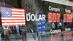 أشخاص ينظرون إلى نافذة وهم ينظرون إلى لافتة تظهر سعر صرف الدولار الأمريكي مقابل البيزو التشيلي في مكتب صرافة في سانتياغو، الخميس 9 أكتوبر/تشرين الأول 2008. 