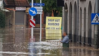 Polonya'nın güneybatısındaki Kłodzko kasabasında, günlerce süren şiddetli yağmurun ardından suyun içinde bir adam duruyor, 15 Eylül 2024