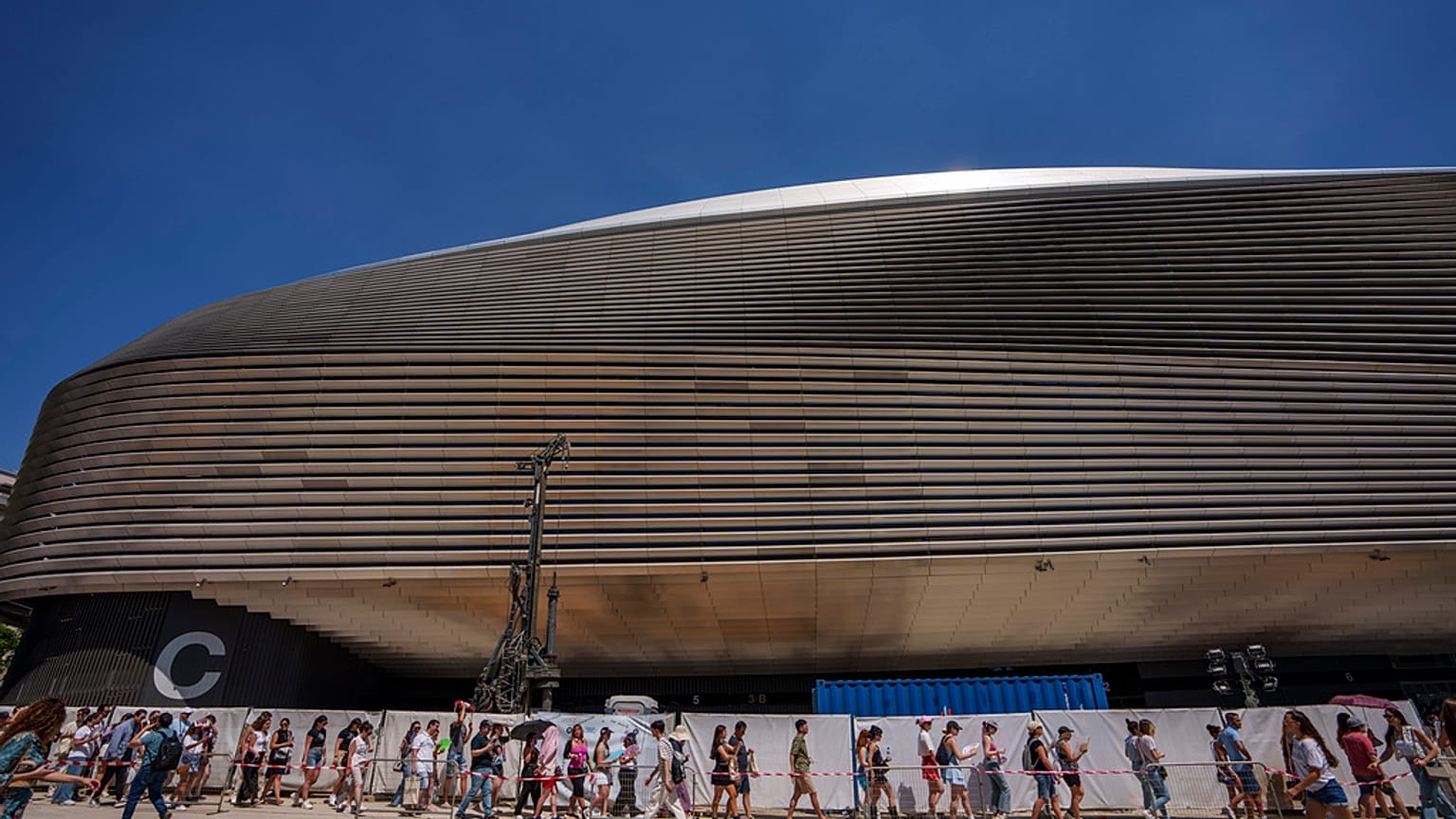Aficionados hacen cola para el concierto de Taylor Swift a las puertas del estadio Santiago Bernabéu de Madrid en mayo de 2024