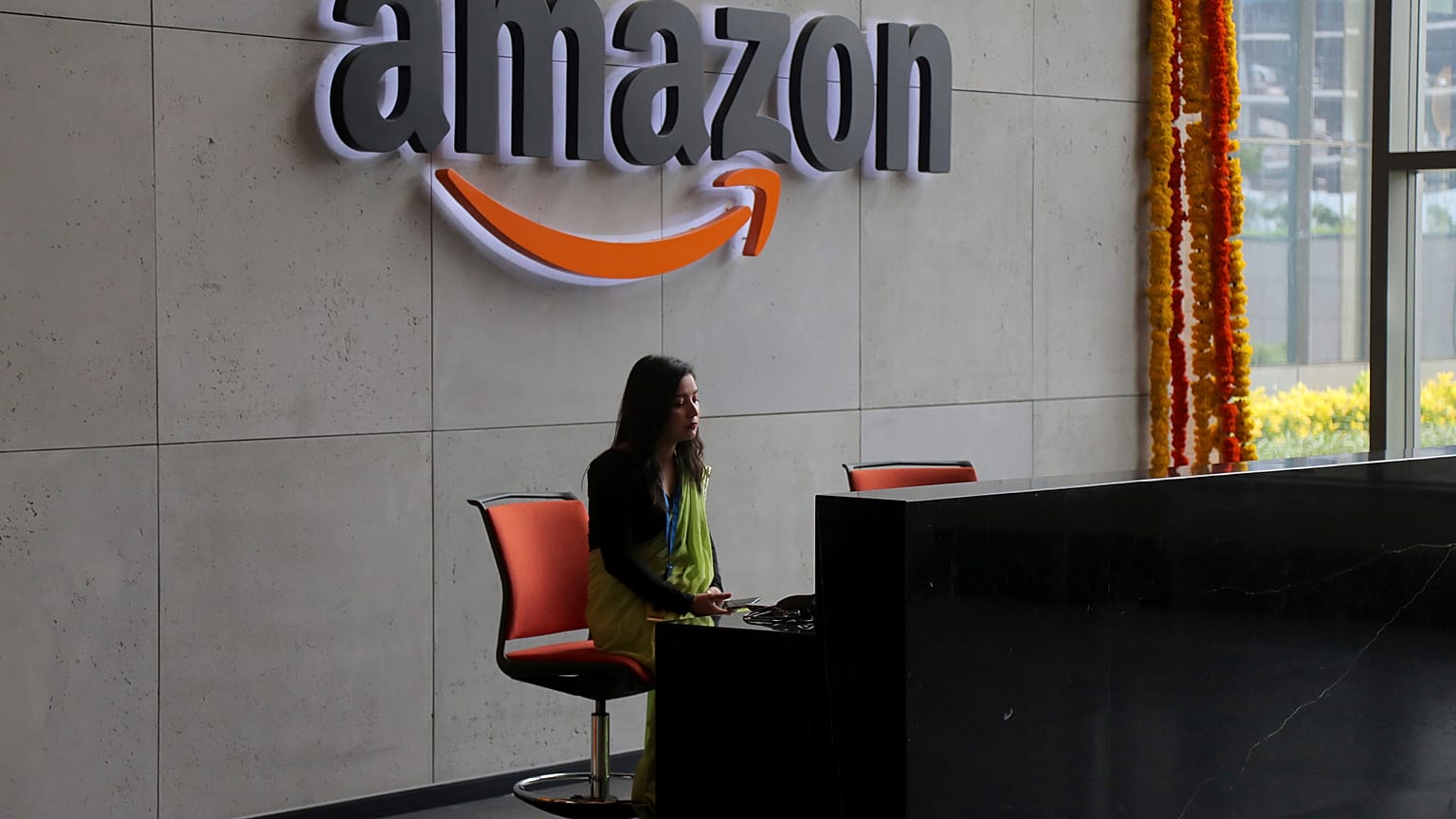Hindistanlı bir çalışan, 21 Ağustos 2019 Çarşamba günü Hindistan'ın Haydarabad kentinde Amazon'un yeni açılan kampüs binasının resepsiyonunda çalışıyor.