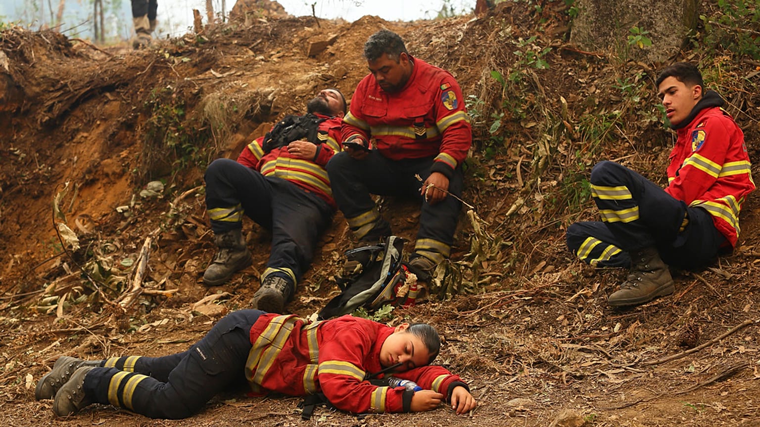 Os bombeiros descansam durante uma pausa na luta contra os incêndios nos arredores de Sever do Vouga, uma cidade no norte de Portugal que tem estado cercada por incêndios.