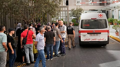 Lebanese Red Cross ambulance passes next of the families of victims who were injured by their exploding handheld pagers.