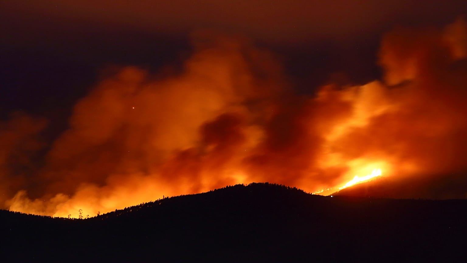Clouds of smoke drift with the strong wind as fires rage on the hills around Sever do Vouga, a town in northern Portugal that has been surrounded by forest fires, Sept. 2024.
