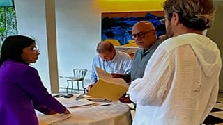 Delcy Rodríguez y Jorge Rodríguez junto a Edmundo González mientras este firma un documento en la Emabajada de España en Caracas.