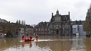 Equipas de salvamento evacuam uma pessoa enquanto o rio Aa inunda Arques, no norte de França, quinta-feira, 4 de janeiro de 2024.