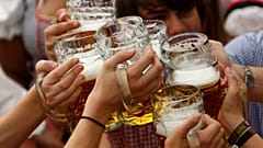 Visitantes levantan sus jarras de cerveza en la carpa Hofbraeuhaus tras la inauguración de la famosa fiesta bávara de la cerveza "Oktoberfest" en una carpa cervecera de Múnich.